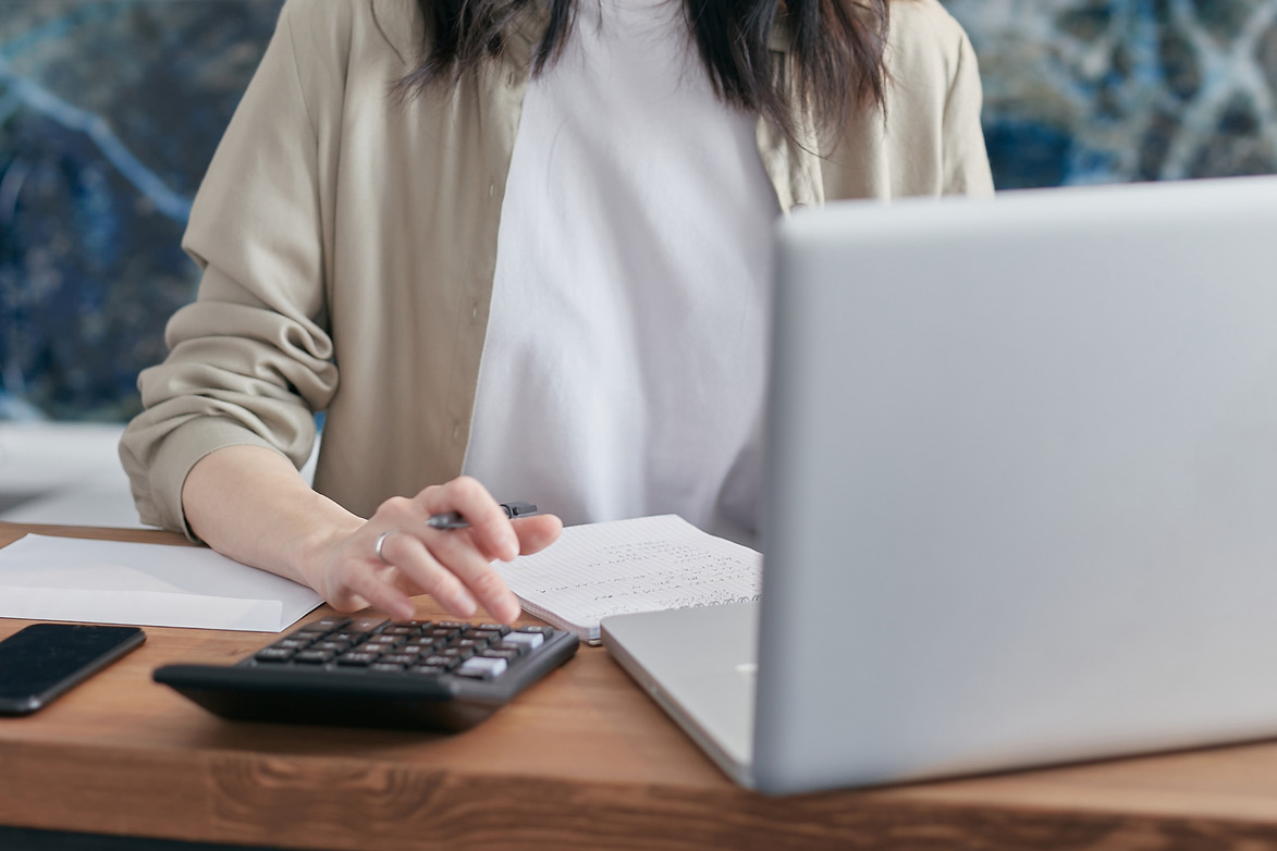 femme sur son ordinateur avec une calculatrice