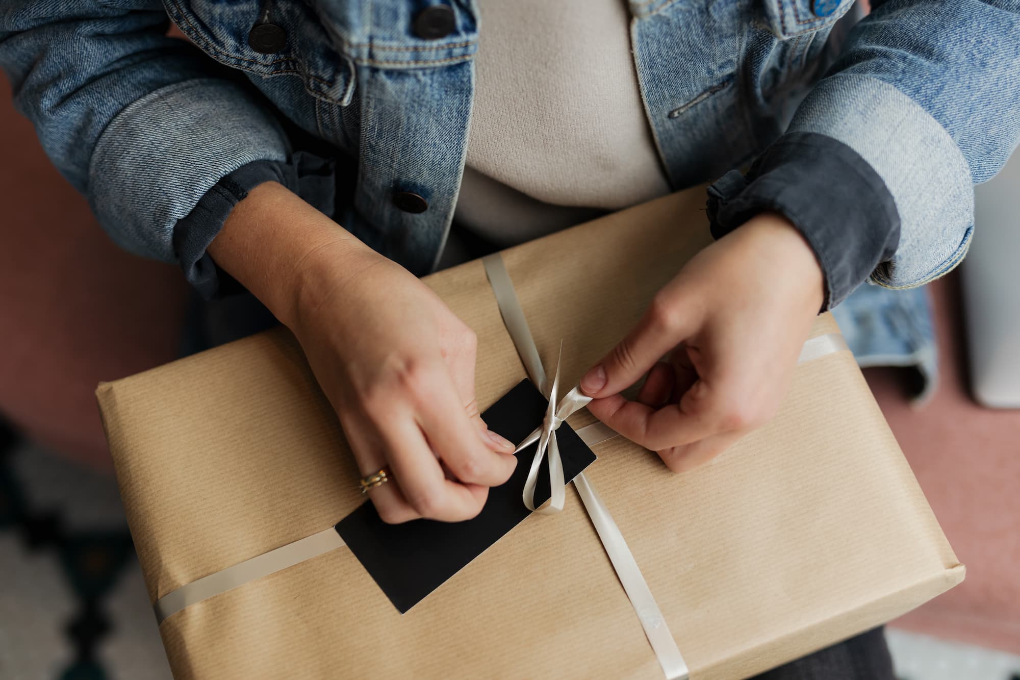 femme qui noue un ruban sur un cadeau