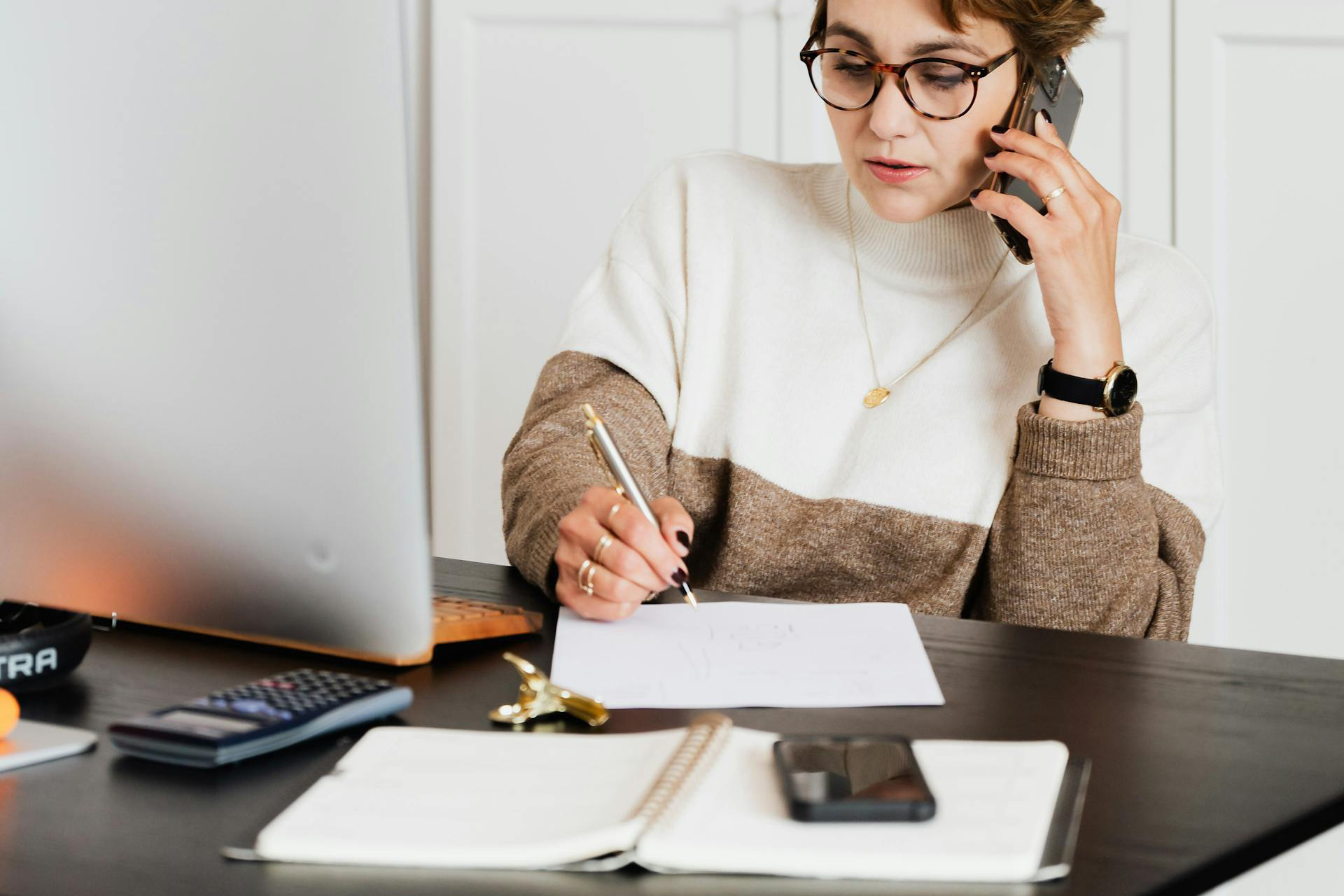 Femme à son bureau avec un téléphone à l'oreille